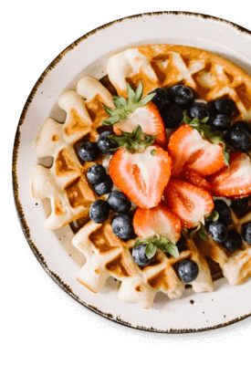 A plate of waffles with strawberries and blueberries.