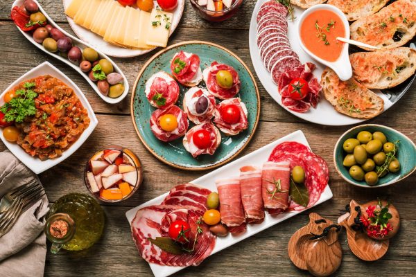 A wooden table topped with plates of food.