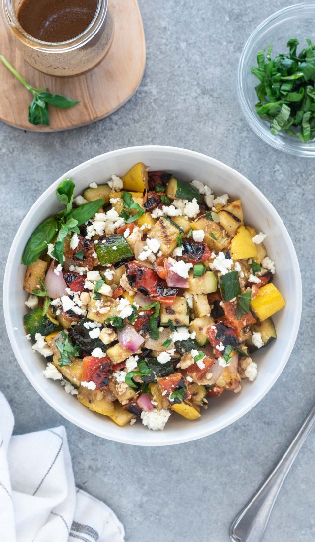 A bowl of salad with feta cheese and vegetables.