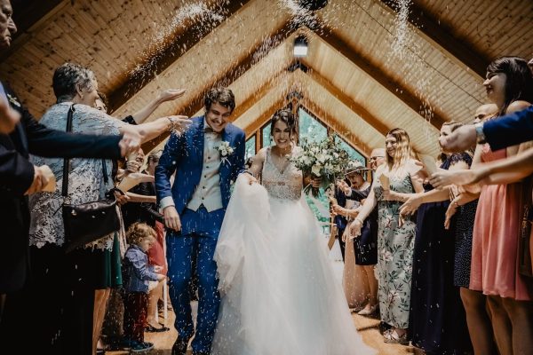 A bride and groom walking through the confetti.